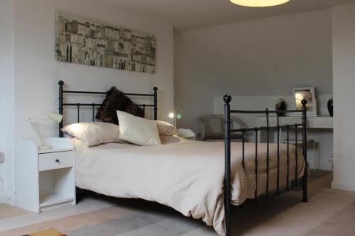 a bedroom with a black bed with white sheets and pillows at Ty Clyd in Pembrokeshire
