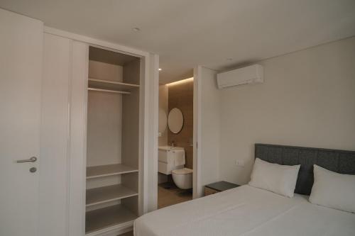 a bedroom with a bed and a bathroom with a toilet at Alba Esposende - Balcony Apartment in Esposende