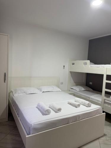 a bedroom with a bed with two bunk beds at Hotel del Mar in Shëngjin