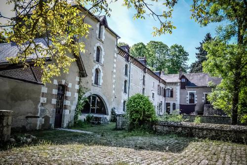 an old house in the middle of a yard at Moulin XVe siècle - Gîte privatif 8 pers - Rivière - Châteaux de la Loire in Vineuil