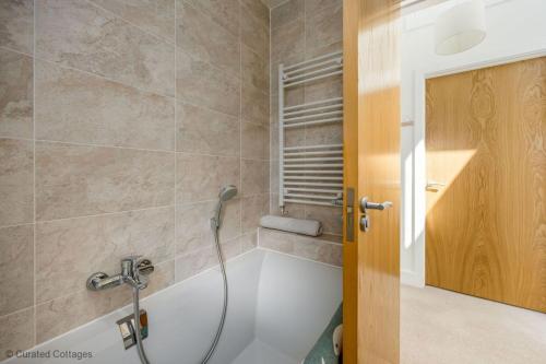 a bathroom with a tub and a shower at Dawn Lighthouse in Dorchester