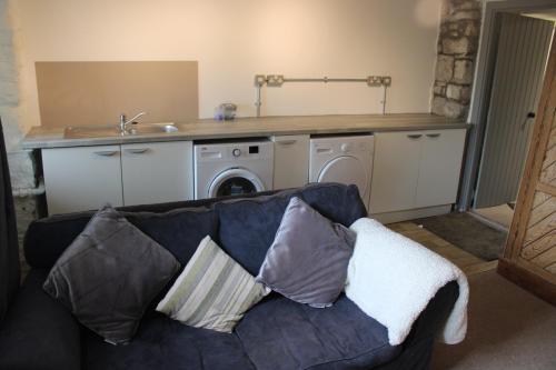 a living room with a couch and a washing machine at Ty Clyd in Pembrokeshire