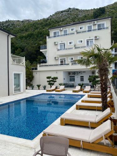 a hotel with a swimming pool with lounge chairs at Hotel del Mar in Shëngjin