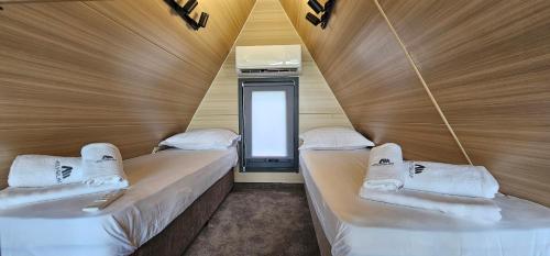 two beds in a small room with a window at Elysium Lozenets in Lozenets