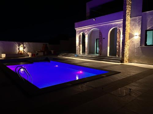 a swimming pool at night with purple lighting at ڤيلا الكرم in Jerash