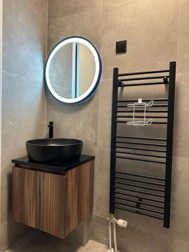a bathroom with a black sink and a mirror at Golden Nest in Tuzla