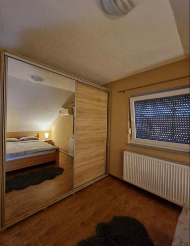 a bedroom with a bed and a large sliding glass door at Apartman Avram in Kotor-Varoš