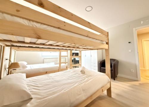 a bedroom with two bunk beds and a desk at Apartamentos Pantón Ribeira Sacra in Ferreira