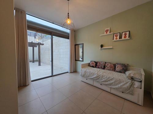 a bedroom with a bed and a large window at Spacious Abdoun 2BR with private garden & pool access in Amman