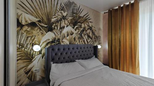 a bedroom with a bed with a mural of plants at Onix Home Love 203 in Mamaia Sat/Năvodari