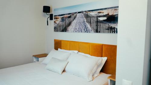 a bedroom with a bed with a picture on the wall at B5 Jurmala Apartments in Jūrmala