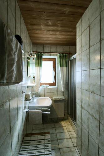 a bathroom with a sink and a window at Pension Anneliese in Schwendt