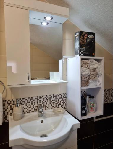 a bathroom with a sink and a mirror at Apartman Avram in Kotor-Varoš