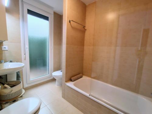 a bathroom with a tub and a toilet and a sink at Capricho de Rovacías in Comillas