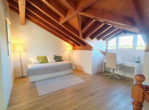 a bedroom with a bed and a desk in a room at Capricho de Rovacías in Comillas