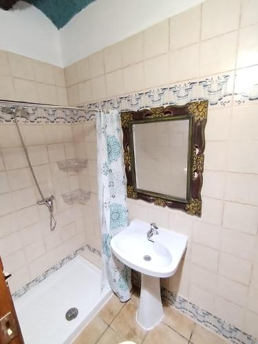 a bathroom with a sink and a shower and a mirror at Casa Sabinar in Navajas