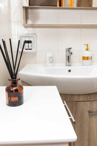 a bathroom with a sink and a vase with sticks at K&J House in Didyma
