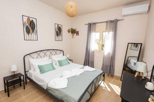a bedroom with a bed with white and green pillows at K&J House in Didyma