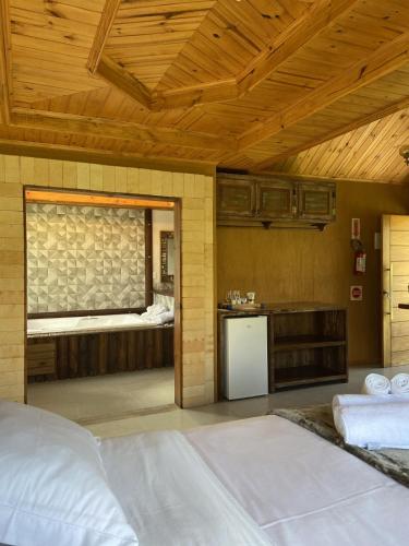 a room with a bed and a kitchen with a window at Pousada Trinca Ferro in Bom Retiro
