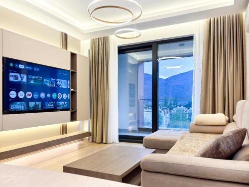 a living room with a couch and a large window at SKY Apartment in Sarajevo