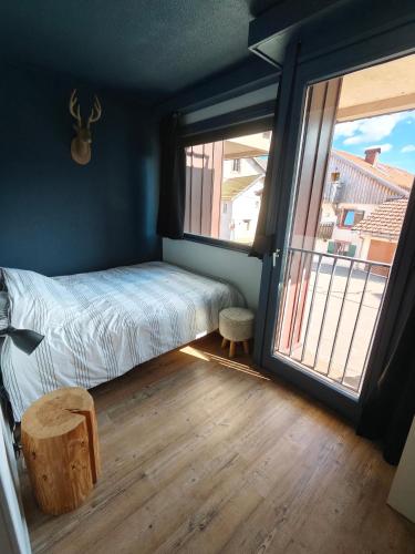 a bedroom with a bed and a large window at La Mauselaine in Gérardmer