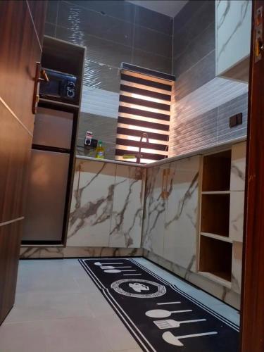a kitchen with a black and white rug on the floor at OYO Serviced Apartment in Egbe
