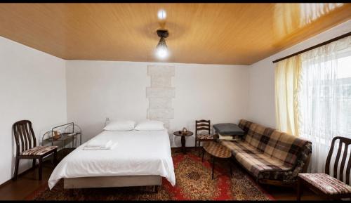 a bedroom with a bed and a couch at Tsatʼer Guest House in Tsatʼer