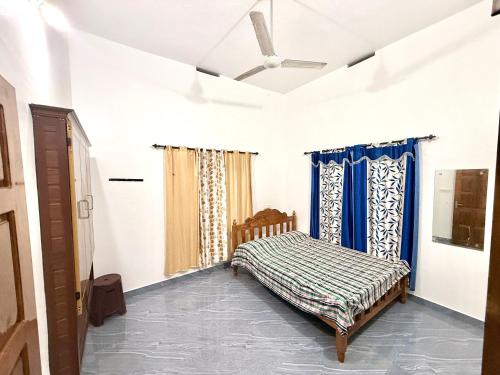 a bedroom with a bed and a ceiling fan at Mridanga Homestay in Iritti
