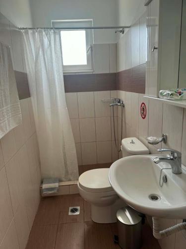 a bathroom with a sink and a toilet and a window at ZOGRAFOS 1 in Haraki