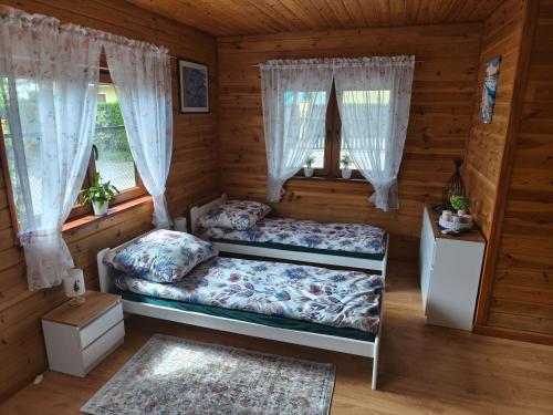 a bedroom with two beds in a log cabin at Domek Słoneczny nad morzem in Kąty Rybackie