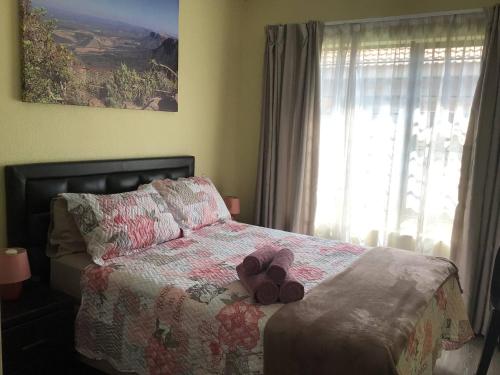 a bedroom with a bed with two slippers on it at Private Secure house in Alberton in Alberton