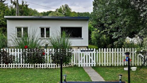 a small white house behind a white fence at Maison La Béa-titude in Serques