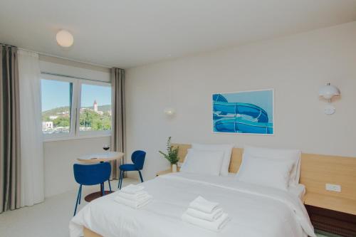 a bedroom with a bed and a table and chairs at áPero Suites in Trogir