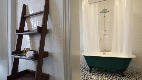 a bathroom with a green tub and a sink at Montebelo Vista Alegre Ílhavo Hotel in Ílhavo