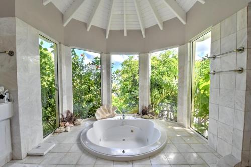 a large bathroom with a tub and large windows at villa coralia - panoramic view in Saint Martin
