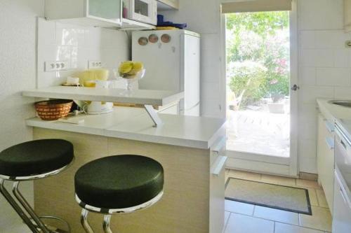 una cocina con una encimera con un taburete negro. en La Croix Valmer, en La Croix-Valmer