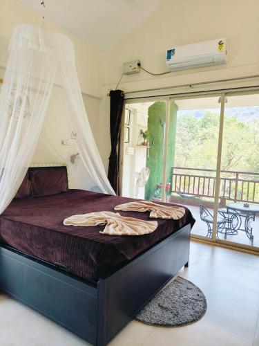 a bedroom with a bed with a mosquito net at Mountainview Paradise - Cozy 1bhk amidst mountains in Karjat