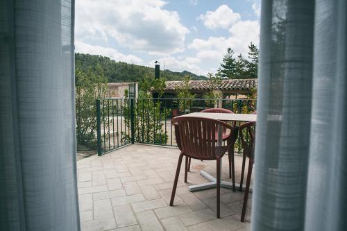 a patio with a table and chairs on a balcony at Can Alemany in Santa Margarida de Montbui