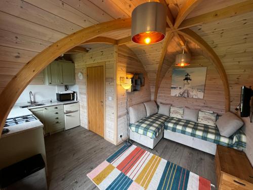 a small room with a bed in a wooden house at Hedgehog Glamping Pod in Leighton