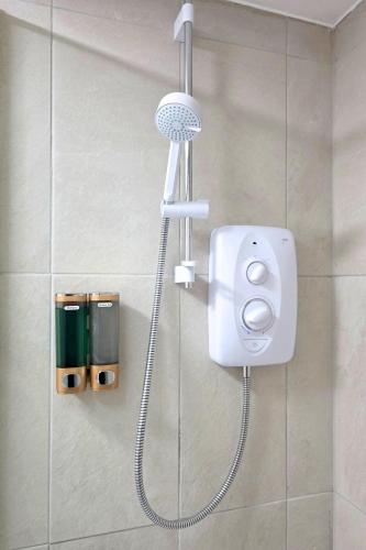 a shower in a bathroom with a blow dryer at Coastal Cottage NC500 in Castletown