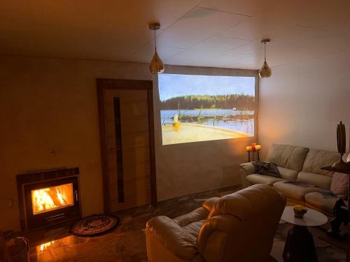 a living room with a couch and a fireplace at Viesu māja Gulbji in Bigauņciems