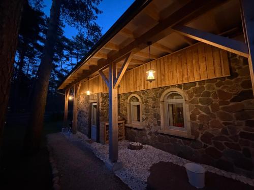 a stone house at night with lights on it at Viesu māja Gulbji in Bigauņciems