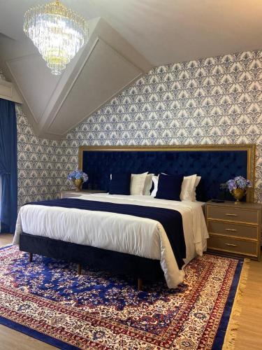 a bedroom with a large bed with a blue wall at Chalés e suítes vila verde in São Bento do Sul