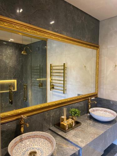 a bathroom with two sinks and a large mirror at Chalés e suítes vila verde in São Bento do Sul