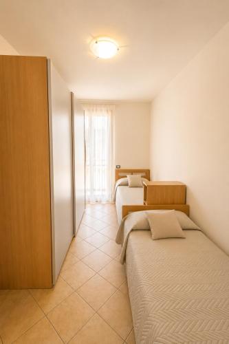 a bedroom with two beds and a window at RESIDENCE STEFANIA - AGENZIA COCAL in Caorle