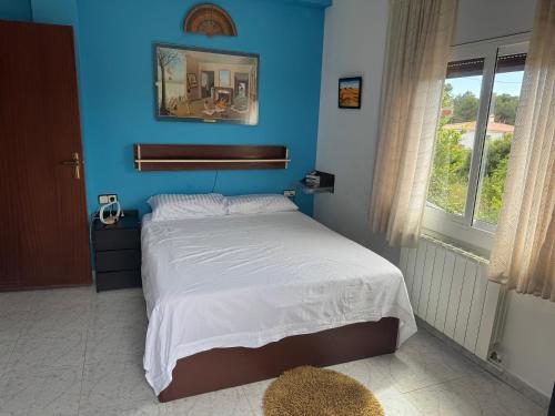 a bedroom with a bed with a blue wall at Villa Maria Mercedes in Olesa de Bonesvalls
