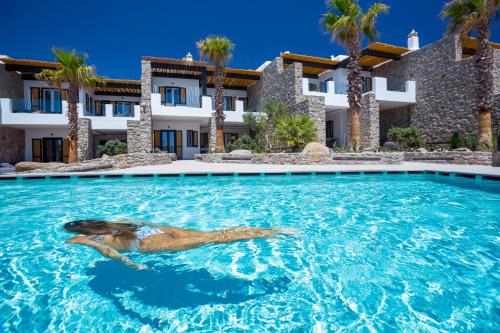 a woman swimming in a swimming pool in front of a building at Tropicana Hotel Mykonos in Paradise Beach