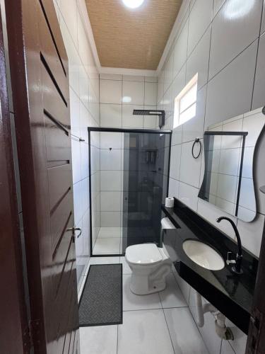 a bathroom with a toilet and a shower and a sink at Hotel Araújo in Capitão Poço