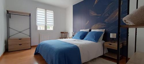 a bedroom with a blue and white bed and a window at Berges de la Suippe in Warmeriville