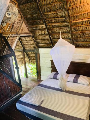 a bedroom with a bed in a straw hut at Jungle Cabin - Satori Natural in Puerto Nariño